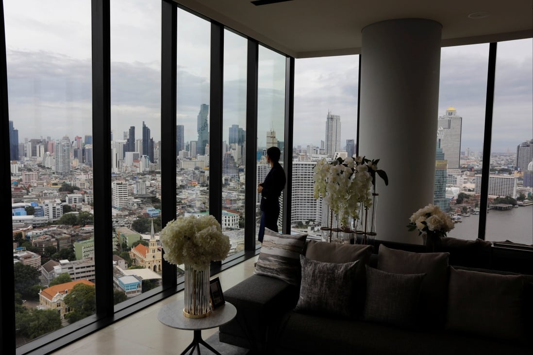 A property agent looks through the window inside a luxury condo building in Thon Buri, Bangkok. Photo: Reuters