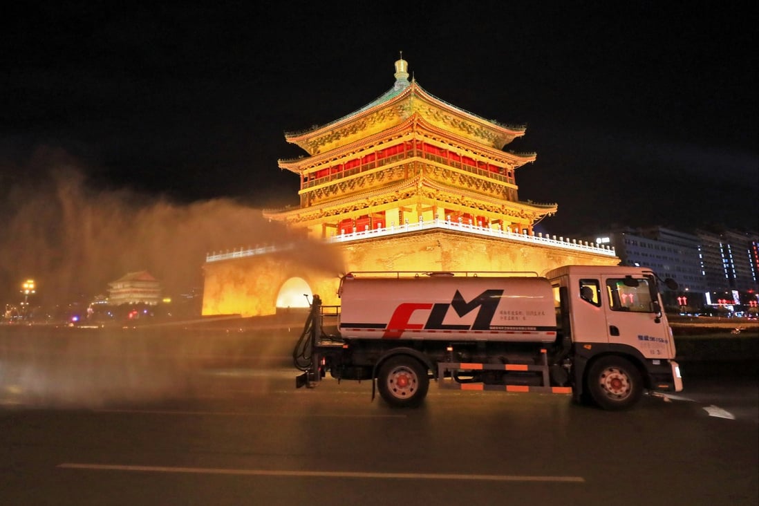 Ein Desinfektionsfahrzeug bei der Arbeit am Sonntagabend in der Nähe des Glockenturms von Xian, während Beamte in der nordwestchinesischen Stadt einen Covid-19-Ausbruch bekämpfen. Foto: Getty Images