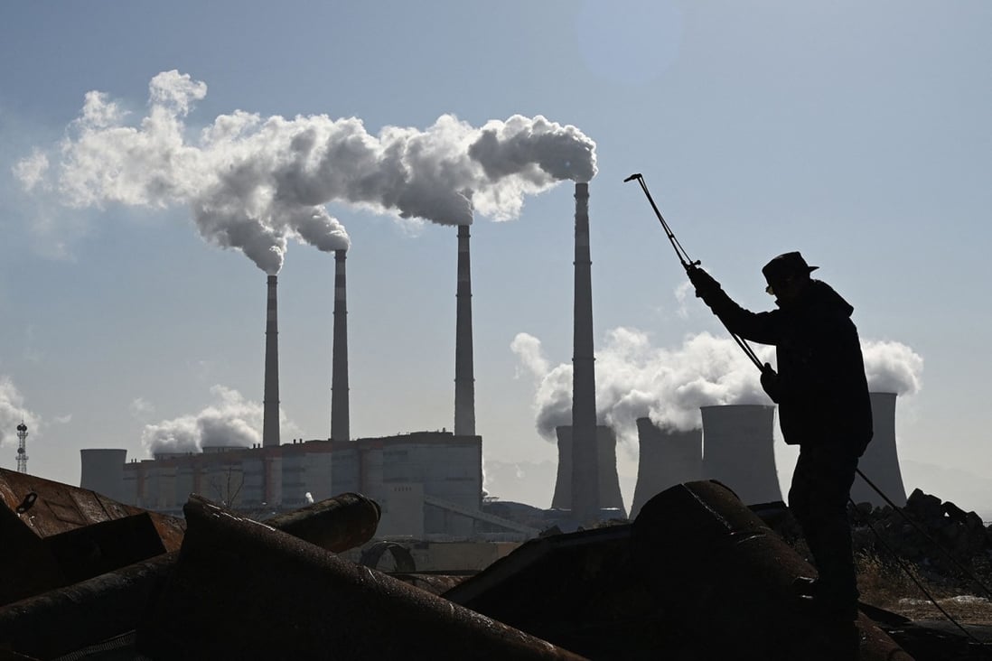 A worker uses a torch to cut steel pipes near the coal-powered Datang International Zhangjiakou Power Station at Zhangjiakou, one of the host cities for the 2022 Winter Olympics, in northern Hebei province on November 12. Plans to shut down factories before and during the Olympics are expected to help reduce smog but will also have an adverse effect on economic growth. Photo: TNS