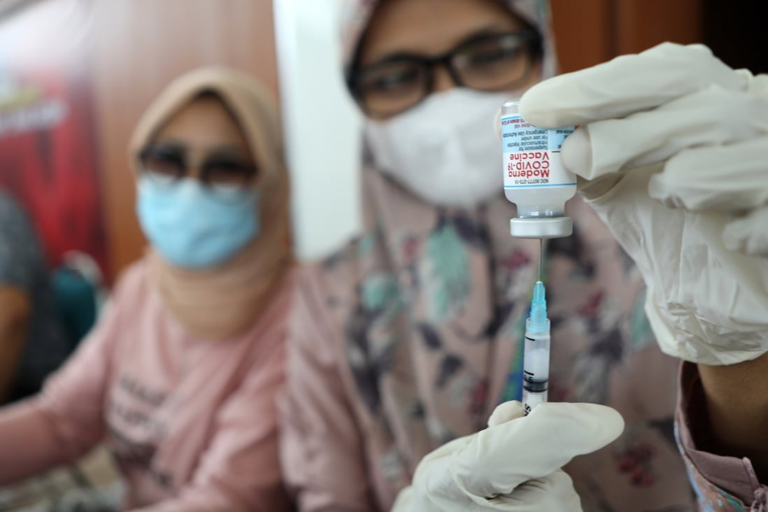 A health care worker prepares a dose of Covid-19 vaccine in Indonesia. Photo: EPA
