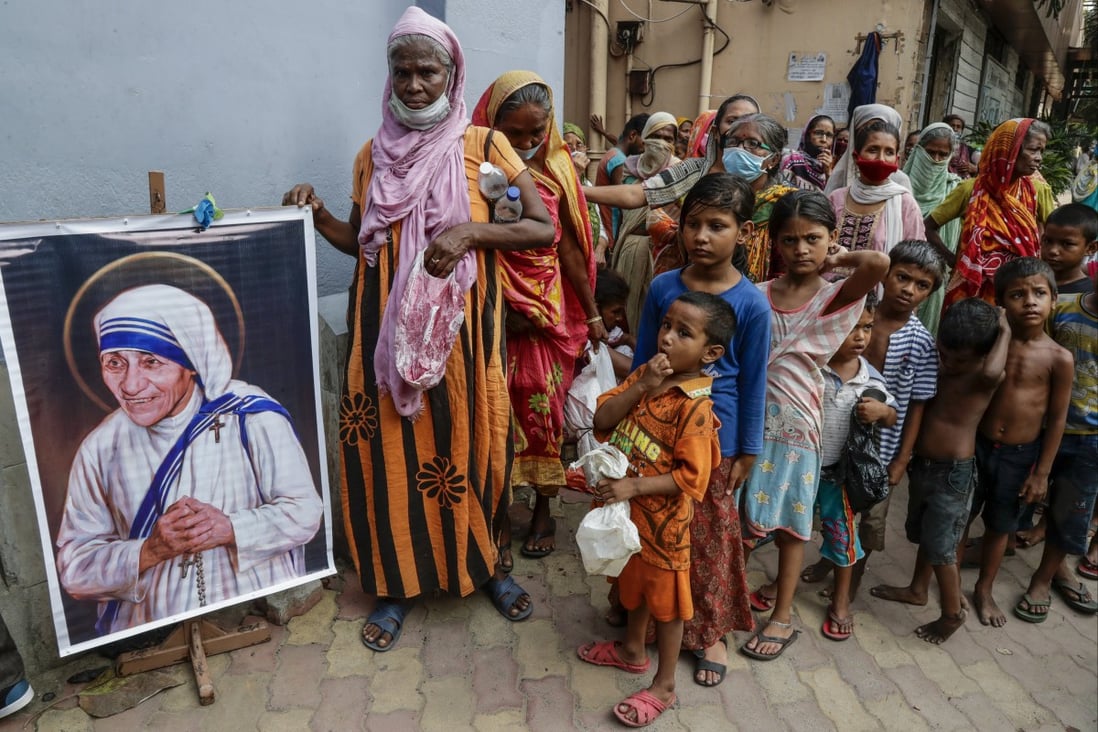 Homeless people gather beside a portrait of Saint Teresa, the founder of the Missionaries of Charity. Photo: AP 