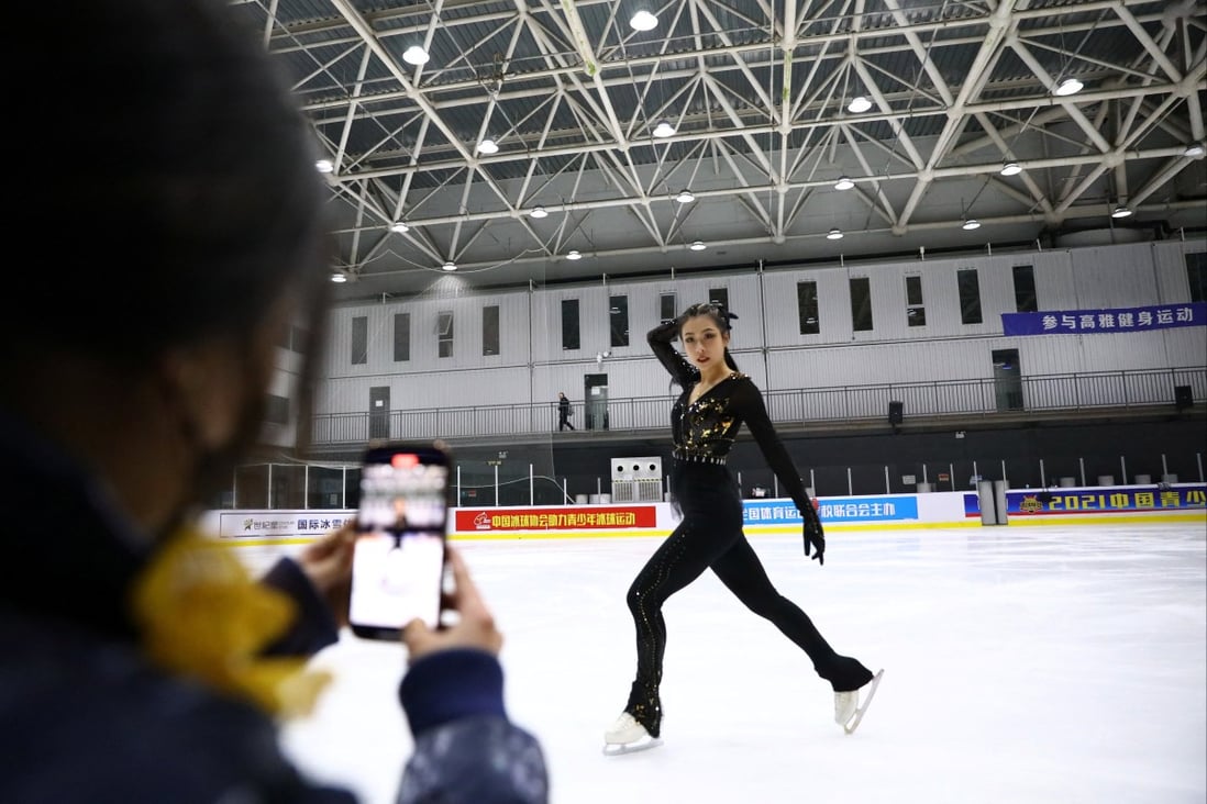 Chinese costume designer Zhang Yifan takes pictures of her sister figure skater Zhang Yixuan in her new outfit, at an ice rink in Beijing, China. Photo: Reuters/Tingshu Wang
