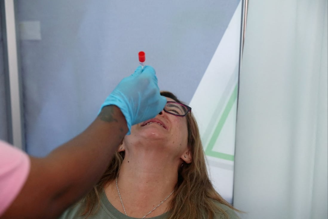 A health worker collects a swab from a traveller at Johannesburg airport in South Africa. Photo: Reuters