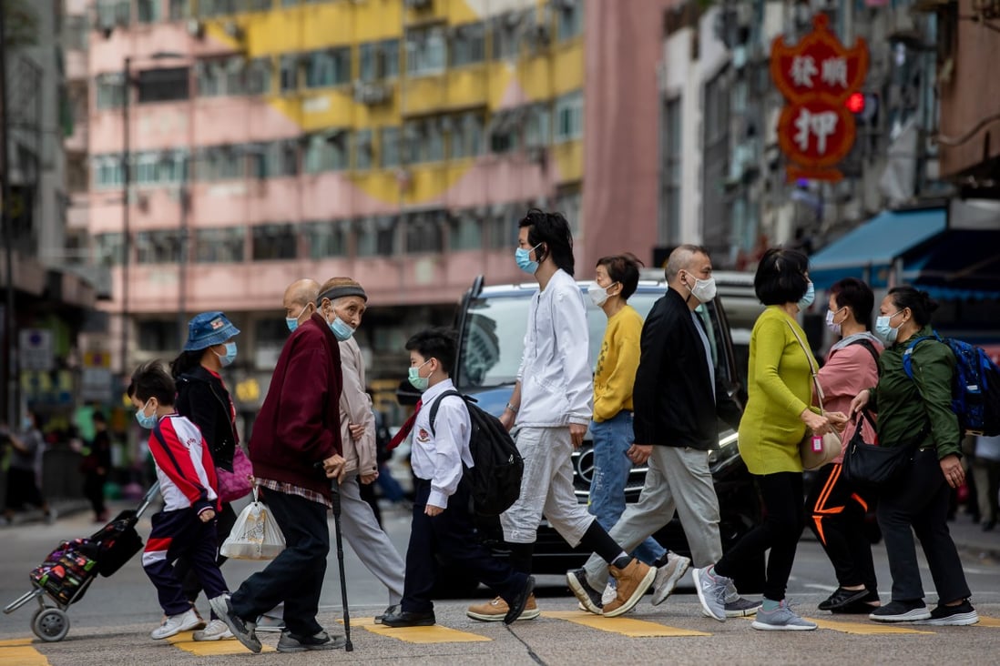 Pedestrians wearing face masks cross the road in Hong Kong. Photo: Bloomberg