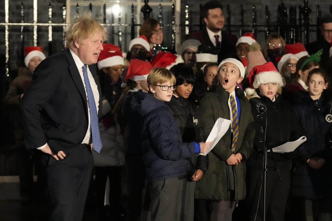 Britain’s Prime Minister Boris Johnson with a children’s choir during a ceremony to switch on Christmas tree lights in London last month. His government has now announced secondary school pupils will have to wear face masks in classrooms when they return to school this week. Photo: AP