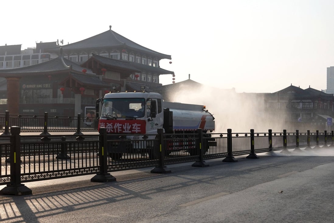 A truck sprays disinfectant on a street in Xian, in northern Shaanxi province, on December 31, 2021. China’s stringent measures against Covid-19 are having spillover effects, such as disrupting work at Samsung’s plants in Xian and weakening the Thai and South Korean currencies. Photo: AFP