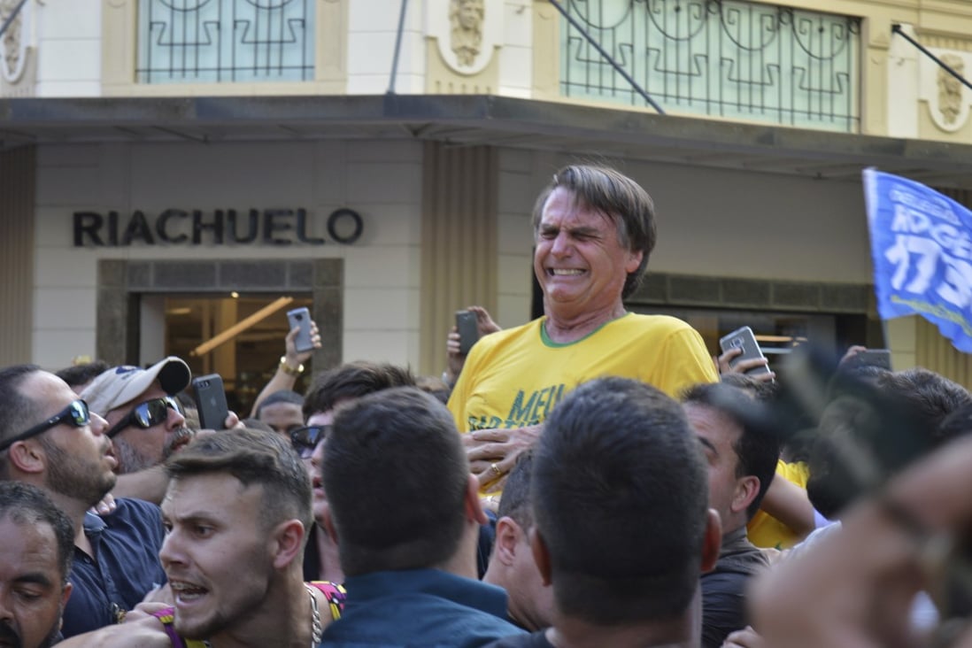 Then a Brazil presidential candidate, Jair Bolsonaro grimaces after being stabbed in the stomach during a campaign rally in 2018. Now president, he has since been hospitalised several times. Photo: AP