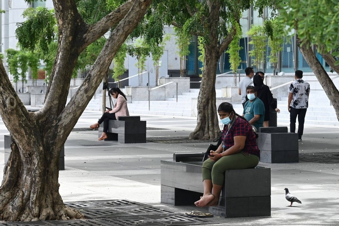 People relax under trees in the financial district of Singapore. Photo: AFP