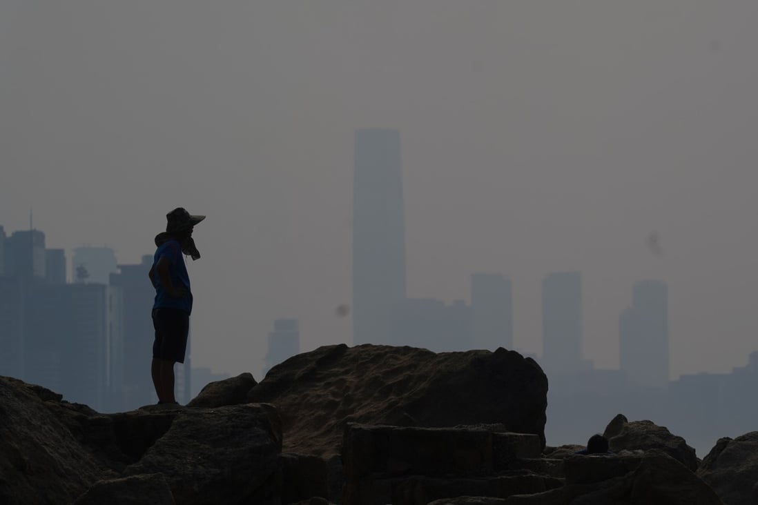 A man stands on rocks at Lei Yue Mun looking out over Victoria Harbour on a high air-pollution day in June last year. Photo: Photo: Sam Tsang