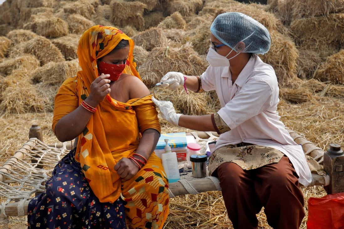 Jabuben Bharwad, 30, receives a dose of the Covishield vaccine against Covid-19 during a door-to-door vaccination drive at Mahijada village in India in December. Photo: Reuters