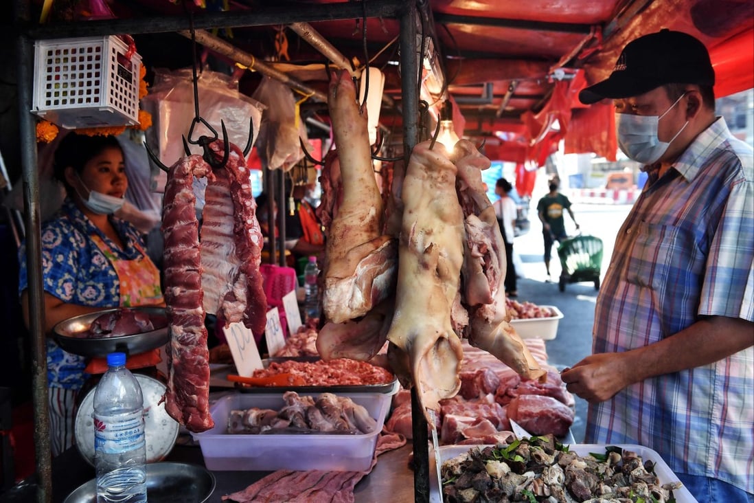 A customer considers cuts of pork at a meat market in Bangkok on Monday. Pork prices have soared in Thailand amid concerns about an African swine fever outbreak. Photo: AFP