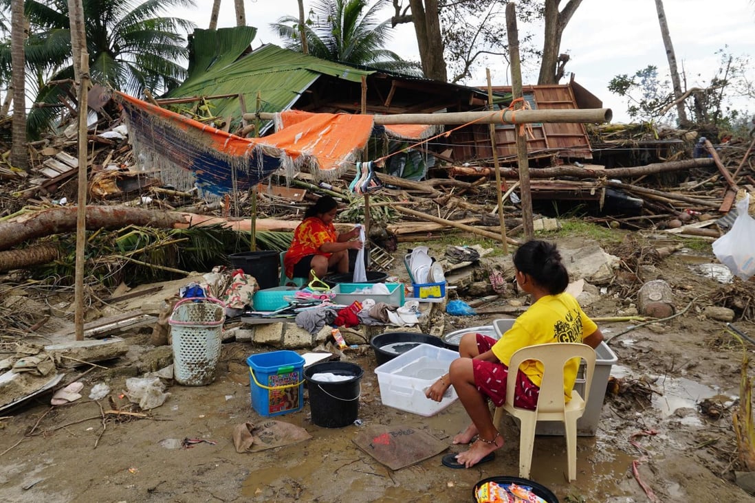 Residents wash their belongings next to their destroyed house in the Philippines’ Bohol province on December 21, 2021, days after super Typhoon Rai caused widespread devastation. Photo: AFP