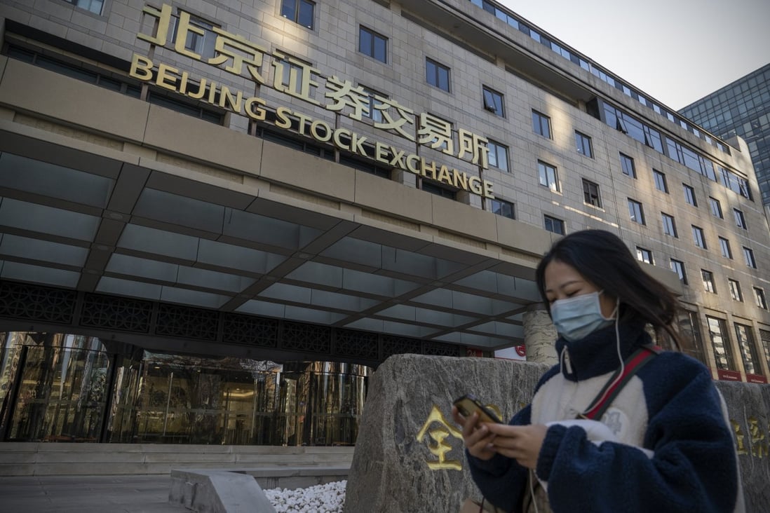 A woman walks past the Beijing Stock Exchange in Beijing on December 13. 2022 could be a year of redemption for Chinese assets. Photo: Bloomberg