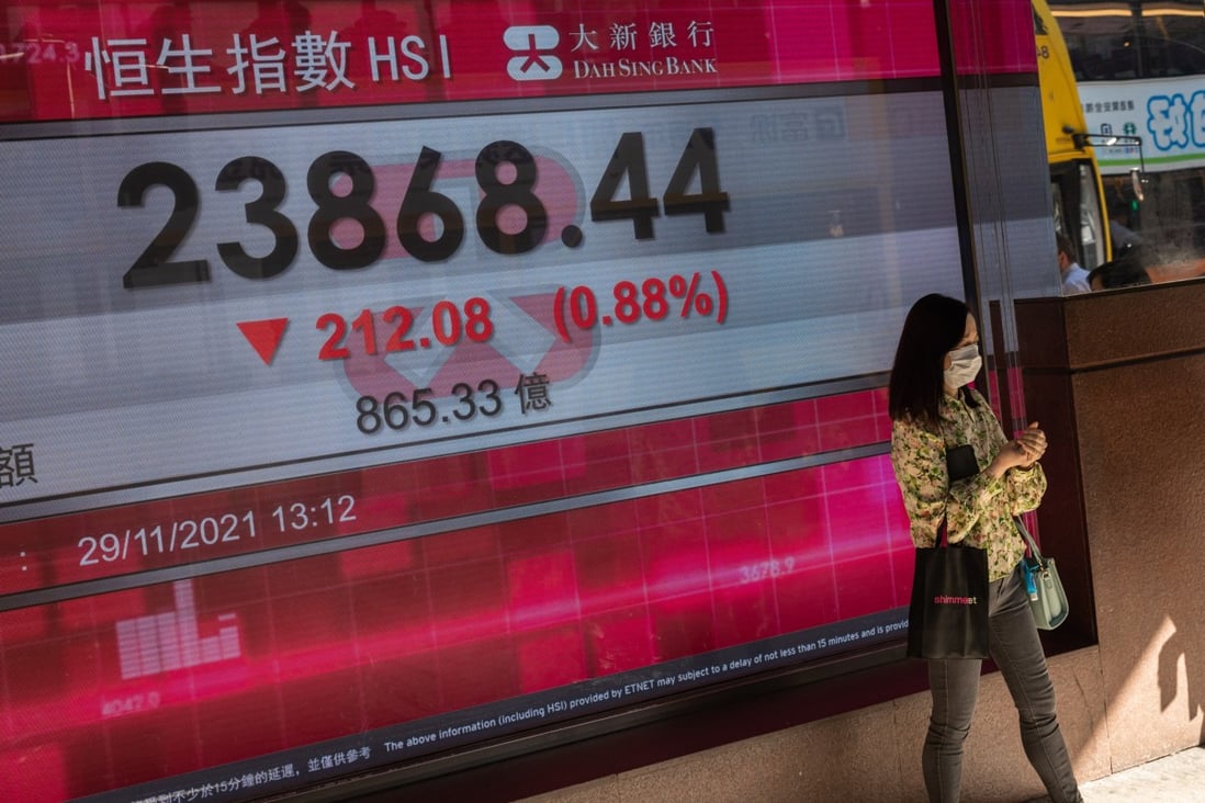 A woman stands next to an electronic board displaying the Hang Seng Index on November 29. Photo: EPA-EFE