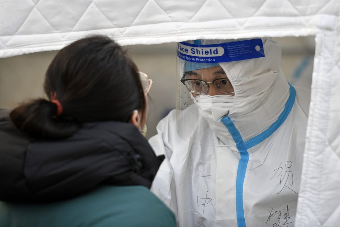 A medical worker takes a swab sample from a Covid-19 testing site in Tianjin on Saturday. Photo: Xinhua