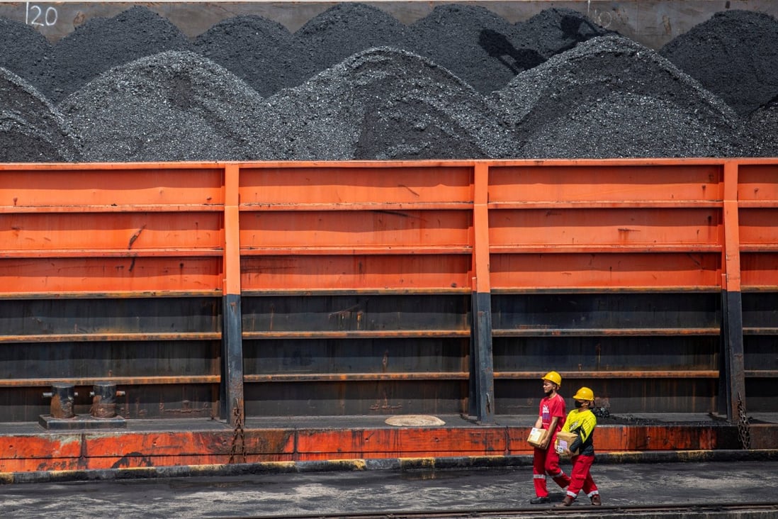 Workers walk near a tugboat pulling coal barges at a port in Palembang, Indonesia. Photo: Reuters