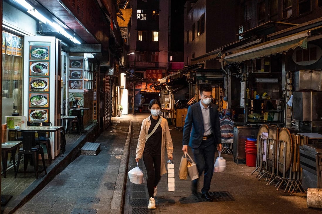 People carry takeaway dinners through a deserted Central district in Hong Kong on January 9, with dining restrictions in place once again. Photo: TNS