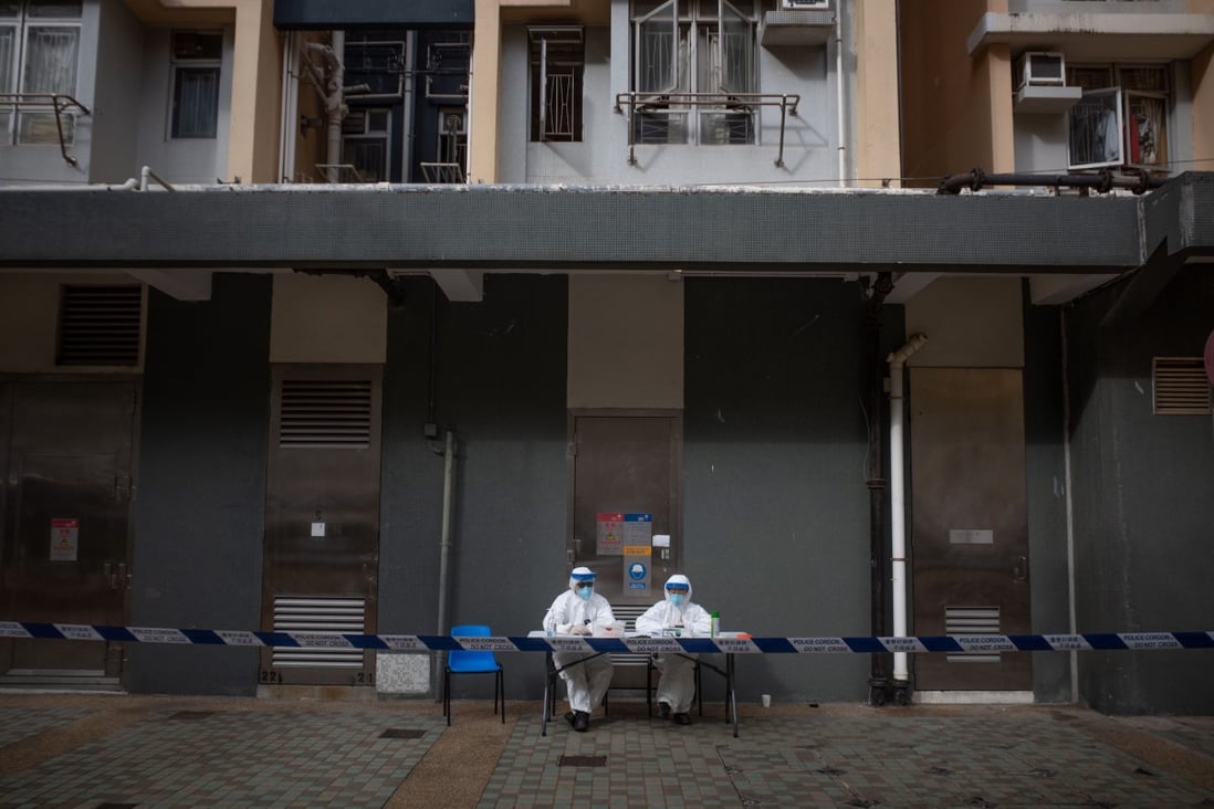 Health officials sit outside a block at Kwai Chung Estate on January 23 after the housing complex was placed under lockdown, one of the most drastic measures Hong Kong has taken to maintain its zero-Covid policy. Photo: Bloomberg