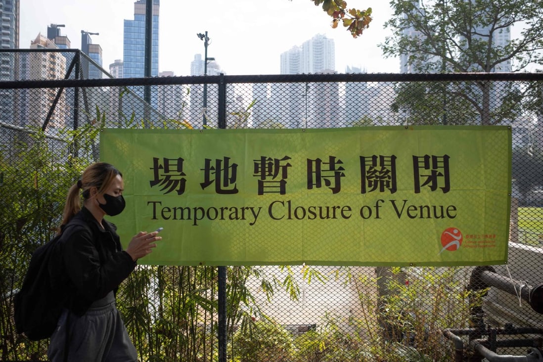 A woman walks past a banner announcing the temporary closure of a venue in Hong Kong’s Causeway Bay area on January 8, after the Omicron variant was detected in the city. Photo: AFP