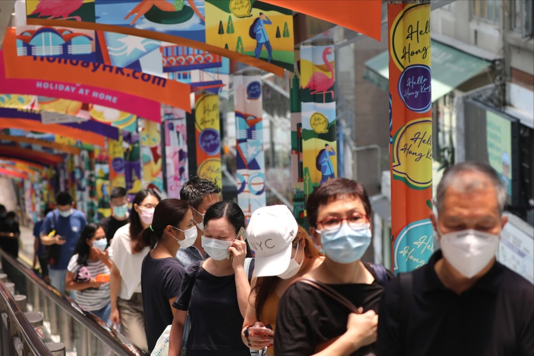 People in masks stand on the Mid-Levels escalator in Central in 2020. Photo: Nora Tam 