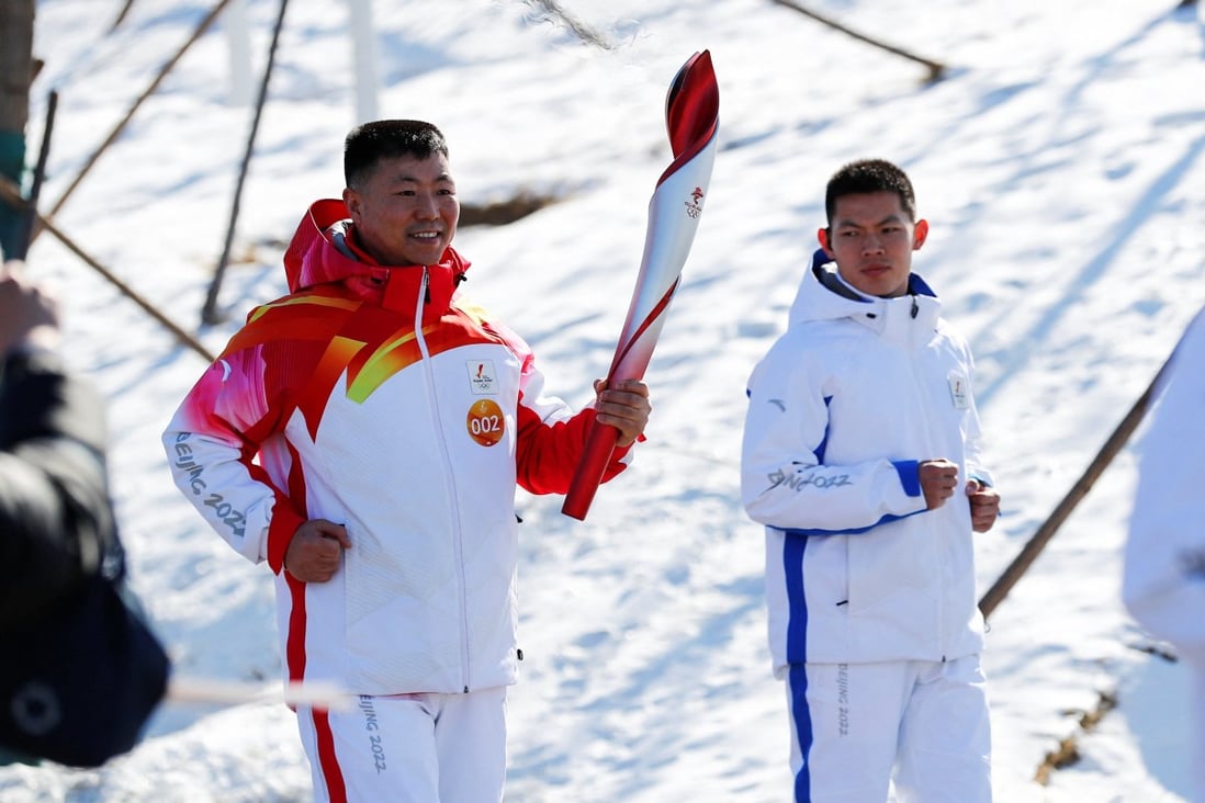 Torch-bearer Qi Fabao, a regimental commander in the People’s Liberation Army, relays the Olympic flame at the Winter Olympic Park on Wednesday. Photo: cnsphoto via Reuters