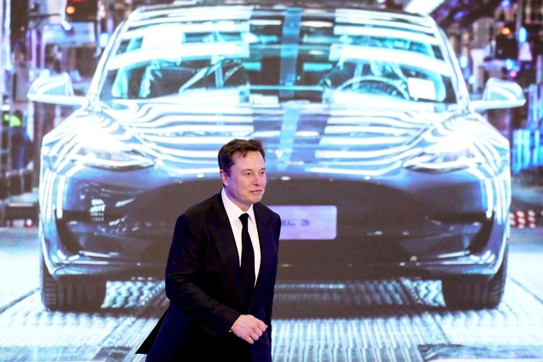 Tesla’s chief executive Elon Musk in front of a screen showing a Tesla Model 3 car. Photo: Reuters.