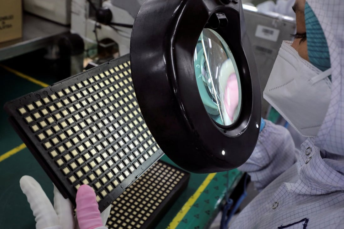 A worker inspects semiconductor chips at a chip packaging firm. Photo: Reuters   