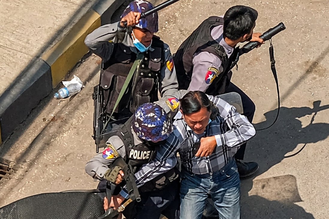 Police arrest a man in Taunggyi, Myanmar on February 28, 2021, as security forces continue to crackdown on demonstrations by protesters against the military coup. (Photo by AFP)