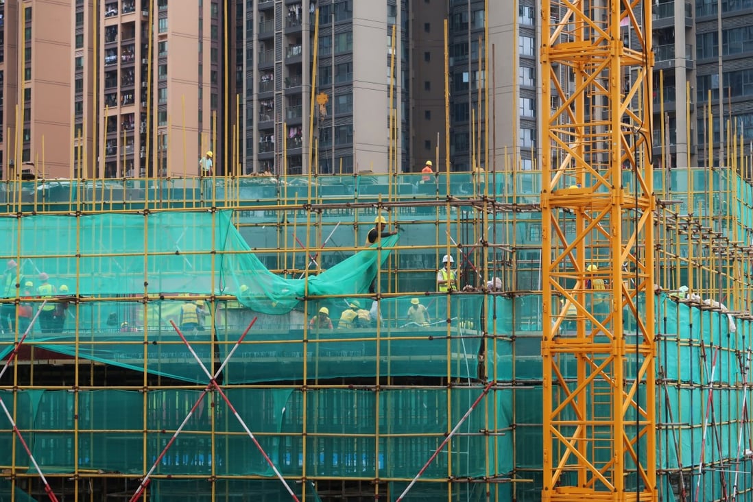 Workers on the scaffoldings of a construction site near residential buildings in Shenzhen on May 17, 2020. Photo: Reuters.