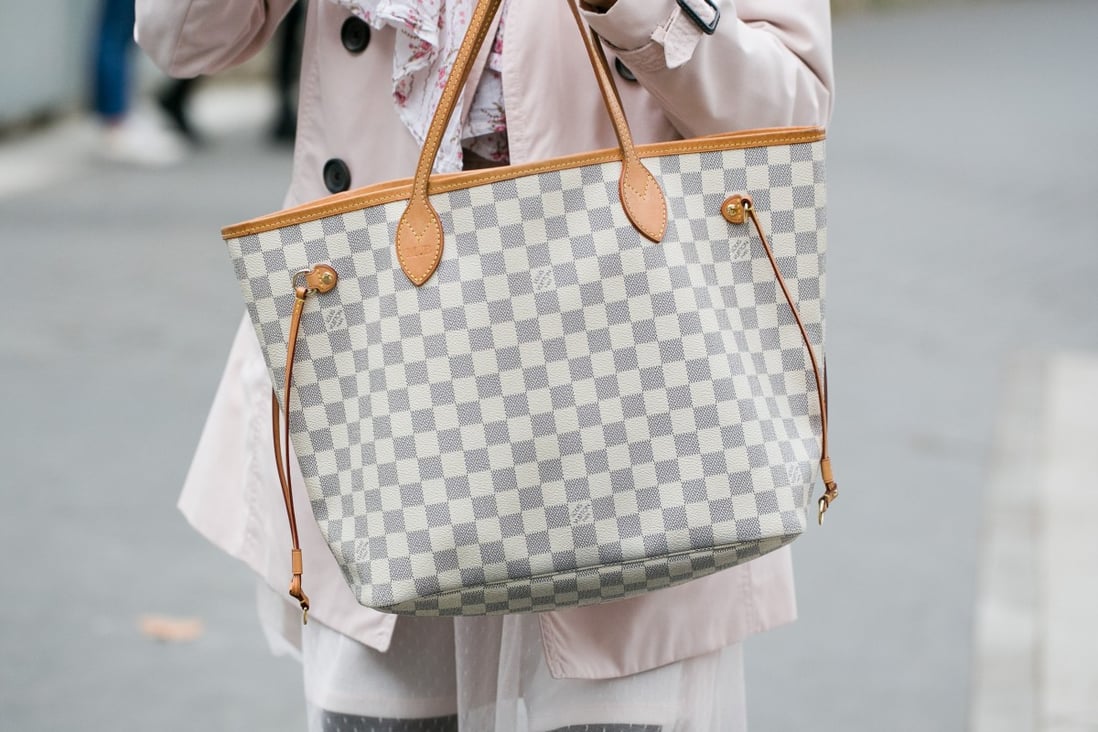 A woman carries a Louis Vuitton handbag during Paris Fashion Week in 2016. The luxury brand has just announced a worldwide price hike. Photo: Shutterstock