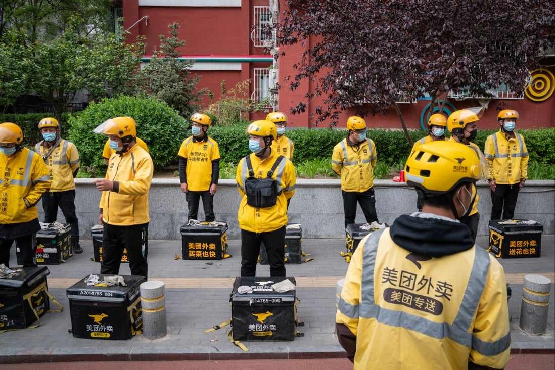 Food delivery couriers for Meituan stand with insulated bags during a morning briefing in Beijing, April 21, 2021. Photo: Bloomberg