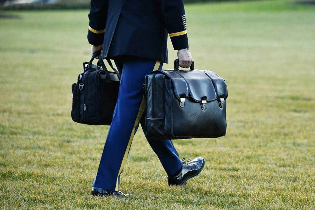 A military aide carries the “nuclear football”, containing nuclear launch codes, as outgoing US president Donald Trump departs from the South Lawn of the White House on January 20, 2021. Photo: AFP  