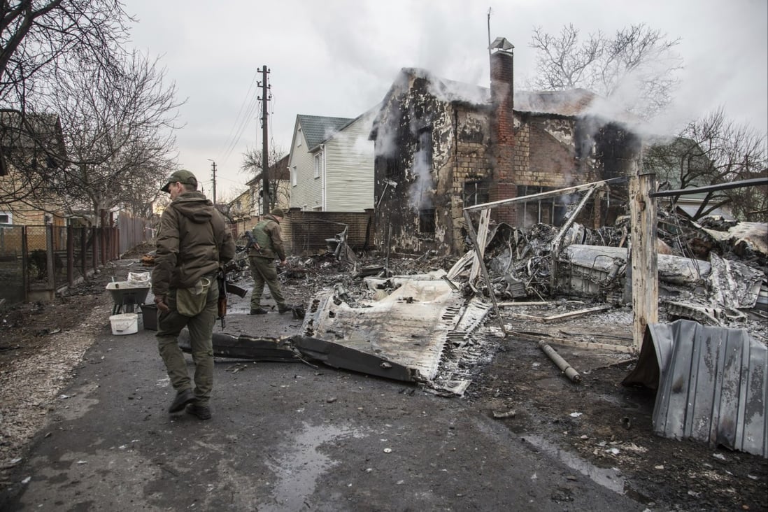 Ukrainian servicemen walk by fragments of a downed aircraft,  in in Kyiv, Ukraine on February 25. Photo: AP