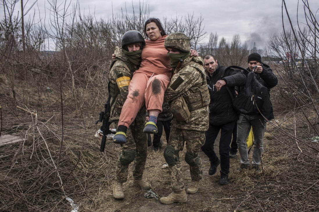 A woman is carried by Ukrainian soldiers while fleeing the town of Irpin, Ukraine on March 6. Photo: AP 