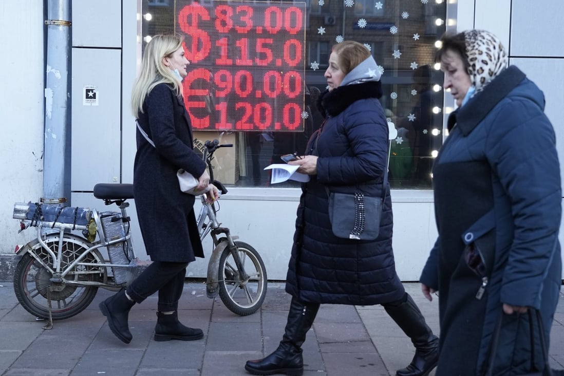 People walk past a currency exchange office in Moscow on February 28. The ripple effects from the West’s sanctions against Russia are driving up commodity prices that were already high. Photo: AP