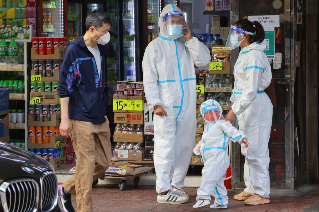 A man walks past a family wearing personal protective gear in Causeway Bay on March 6. Photo: Dickson Lee