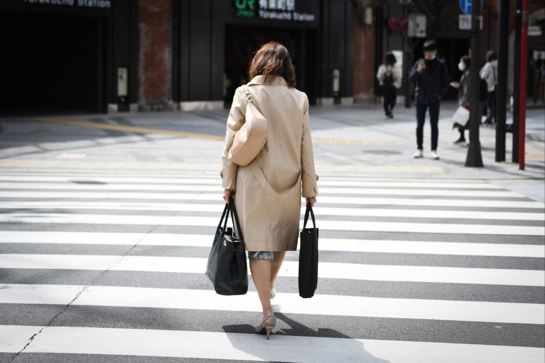 A woman crosses a street in Tokyo, Japan, on March 7. Employers often see little merit in offering jobs to women wanting to return to work in their 40s. Photo: Bloomberg