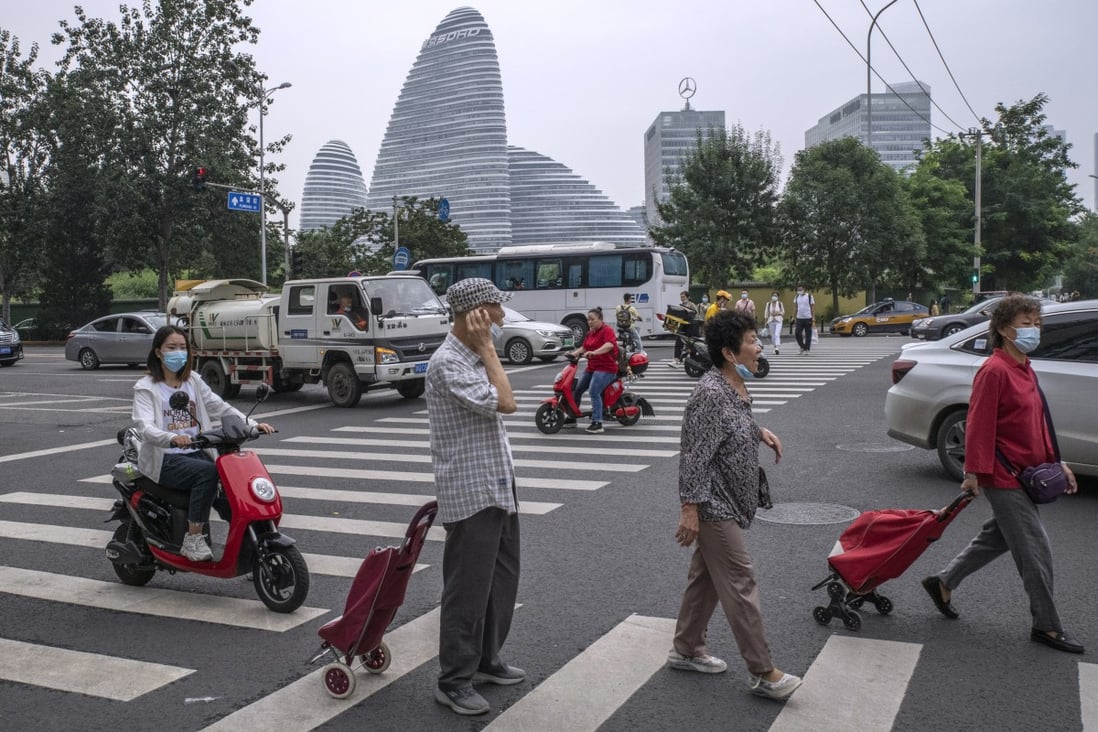 Pedestrians cross a road near Soho China’s Wangjing Soho project in Beijing. Photo: Bloomberg