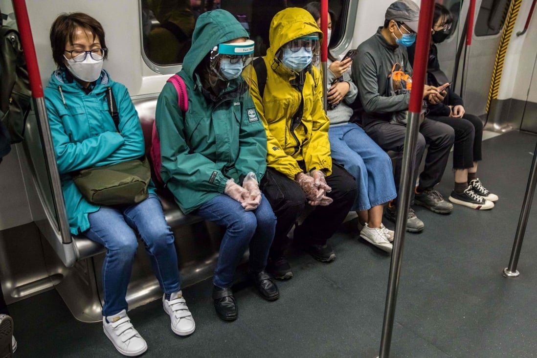 People wearing face shields and masks commute on the MTR on March 10. Universal testing and a partial lockdown may well suppress the fifth wave to a large extent, but how often can we go through the same exercise without being drained by fatigue and frustration? Photo: AFP