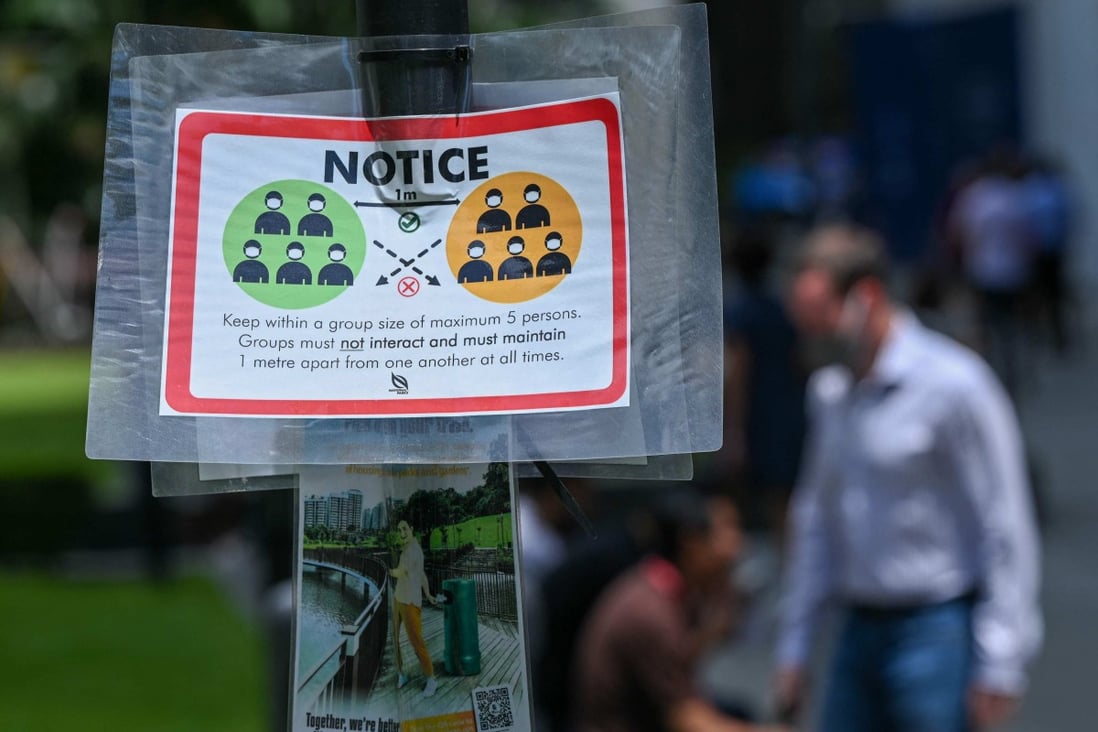 A notice warning people not to gather in groups larger than five to help stop the spread of Covid-19 is displayed at Raffles Place in Singapore in February. Photo: AFP