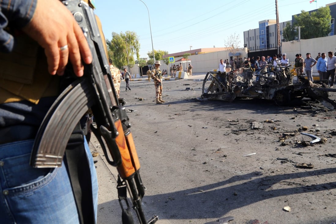 Kurdish security forces and citizens inspect the site of a car bomb attack in front of the main security forces headquarters in Arbil, Iraq in 2013. Photo: AP