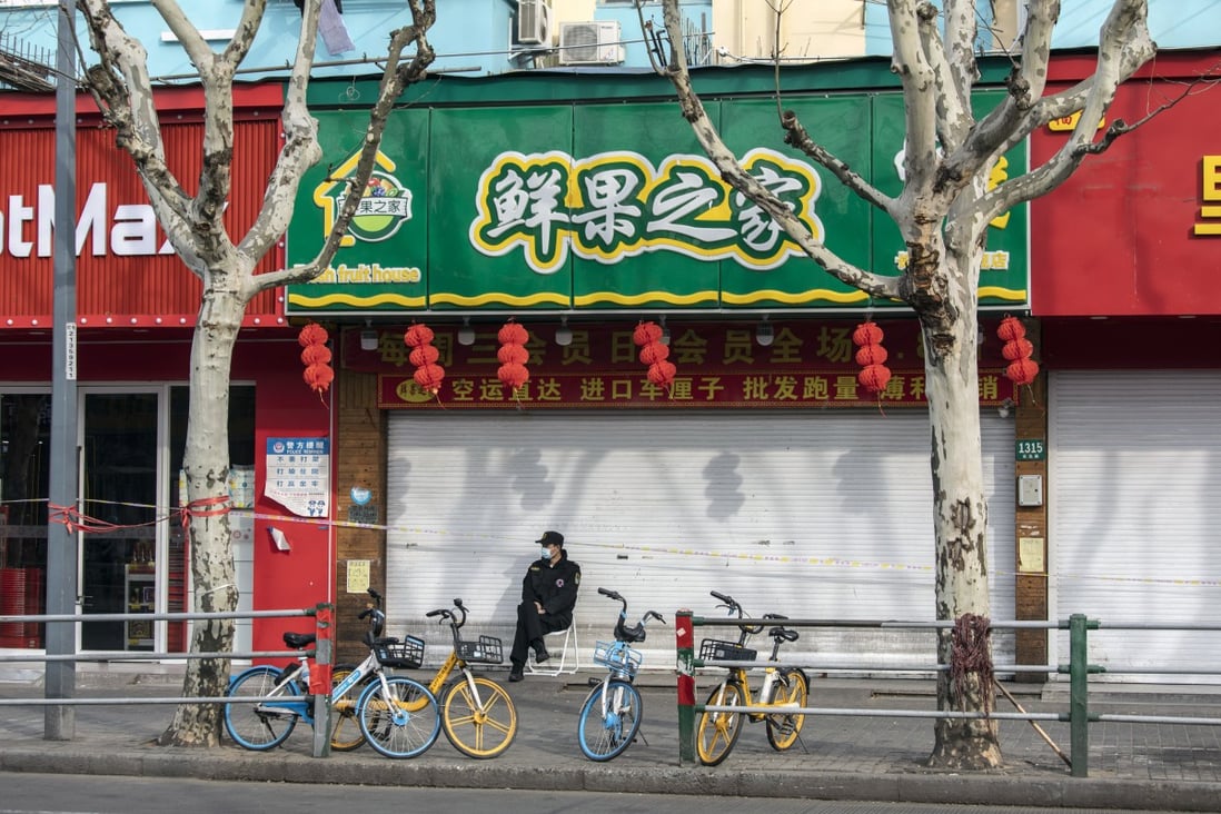 A security guard in front of closed stores at a residential neighborhood placed under lockdown due to Covid-19 in Shanghai, on Thursday, March 10, 2022. Photo: Bloomberg