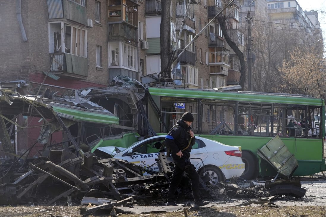 A Ukrainian soldier passes by a destroyed a trolleybus and taxi after a Russian bombing attack in Kyiv, Ukraine, on Monday. Photo: AP