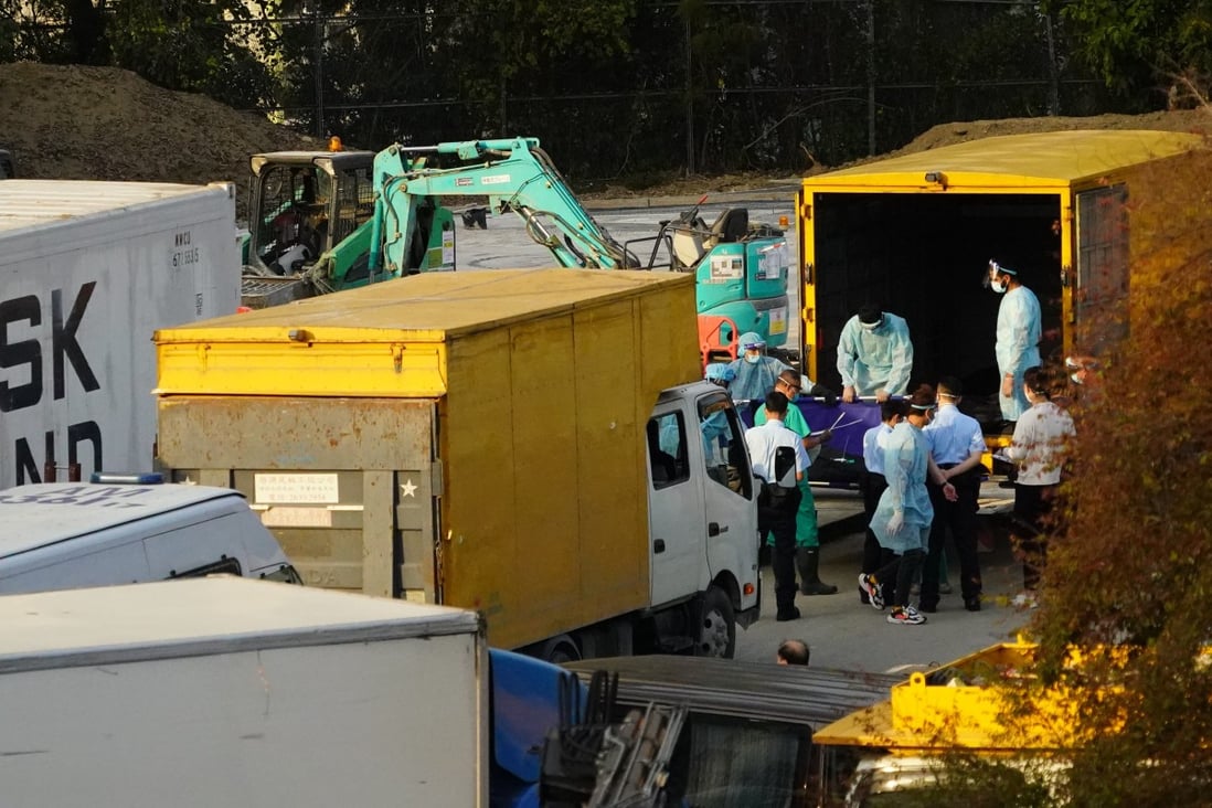 Workers transfer bodies of the deceased into a refrigerated shipping container outside the Fu Shan Public Mortuary on March 11, as mortuaries are reaching capacity amid the fifth wave of Covid-19. Photo: Felix Wong