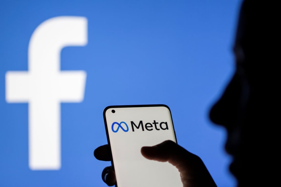 A woman holds a smartphone with Meta logo on it in front of a displayed Facebook logo in this illustration taken, October 28, 2021. Photo: Reuters