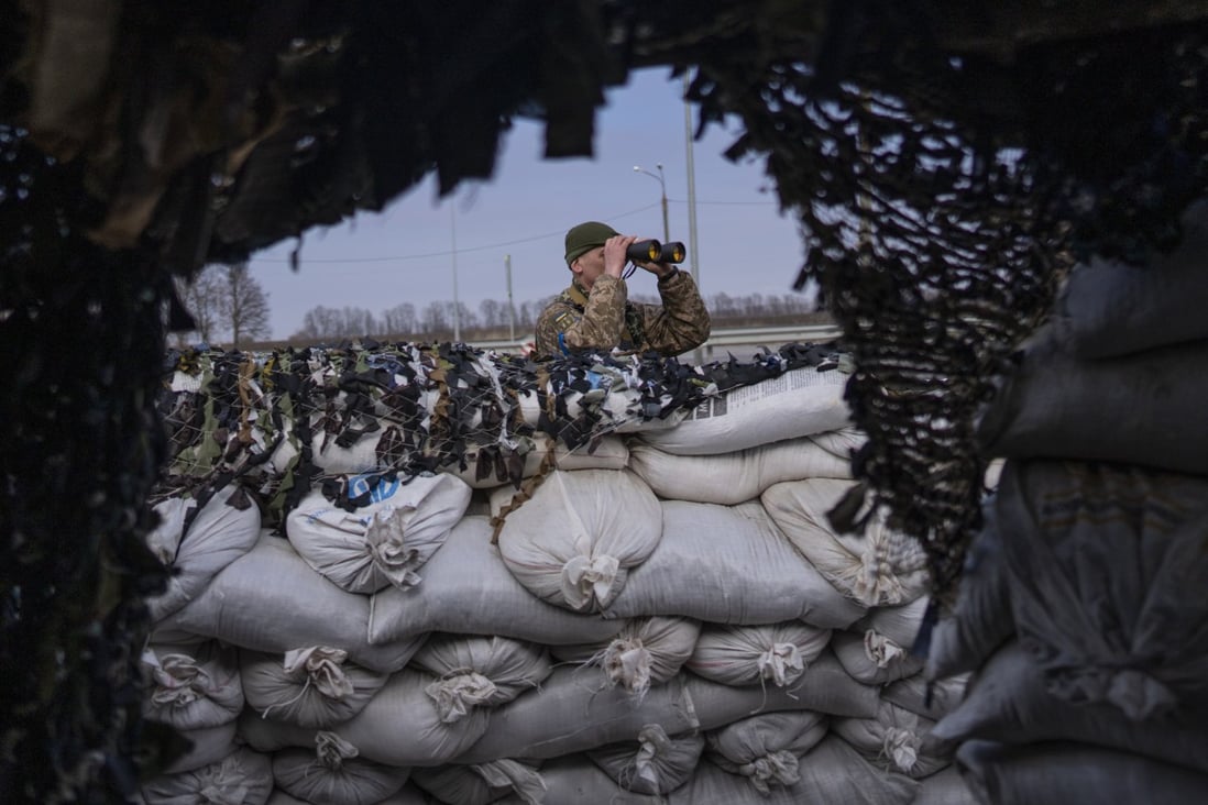 A Ukrainian soldier looks through binoculars at a military check point. Photo: AP