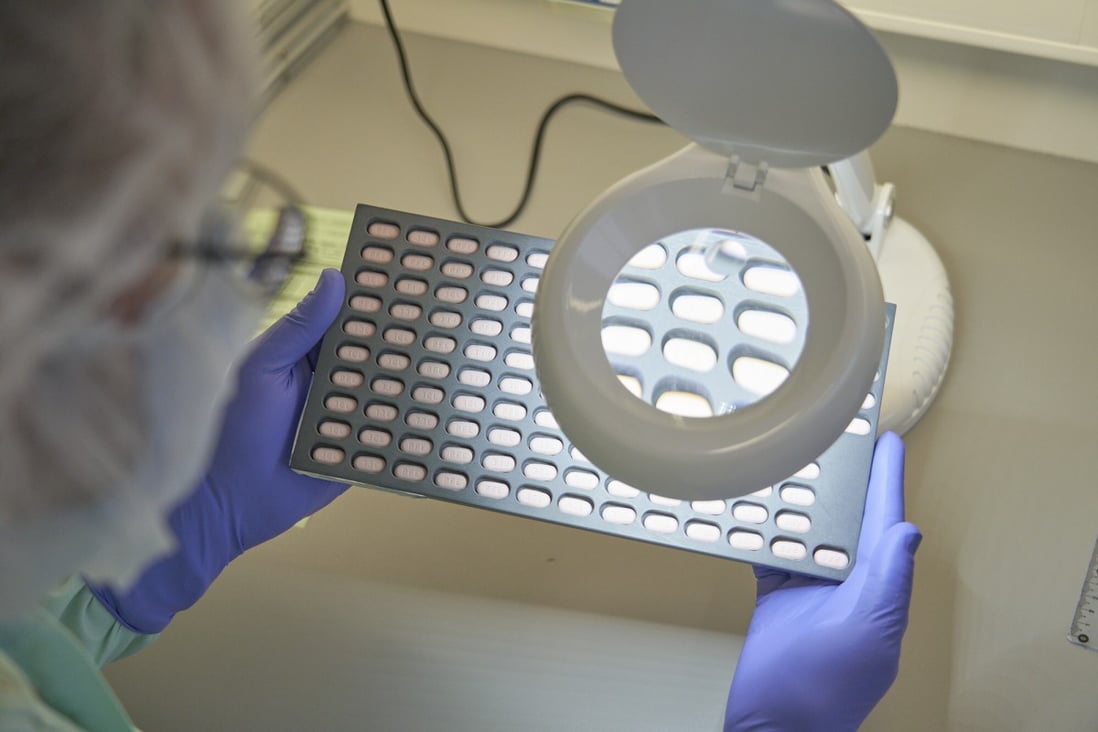 A lab technician visually inspects Paxlovid tablet samples in Freiburg, Germany in December 2021. Photo: Pfizer via AP 
