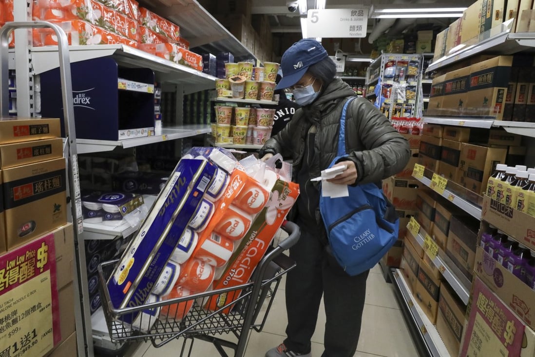 A woman stocks up on toilet paper rolls at a supermarket in Mong Kok, Hong Kong, in February 2020, as panic buying sparked by the coronavirus spreads through the city. Photo: Nora Tam