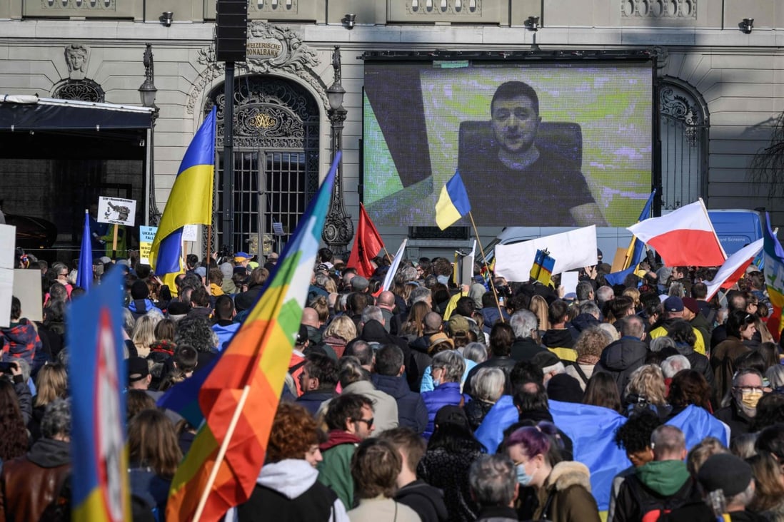 Ukrainian President Volodymyr Zelensky is displayed on a giant screen after delivering a live voice message during a demonstration against the Russian invasion of Ukraine in front of the Swiss House of Parliament in Bern, Switzerland on March 19. Photo: AFP