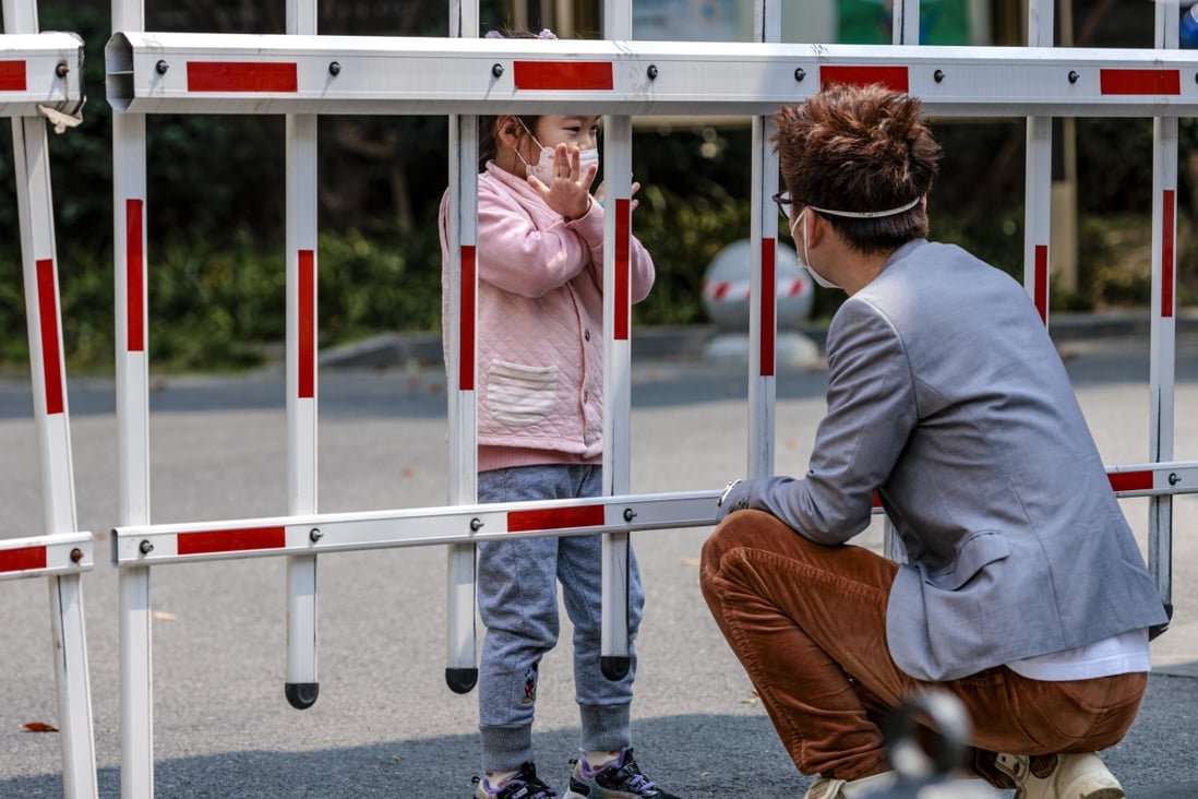 A man talks to his daughter through a fence at a residential compound under Covid-19 quarantine in Shanghai on March 14. Photo: EPA-EFE